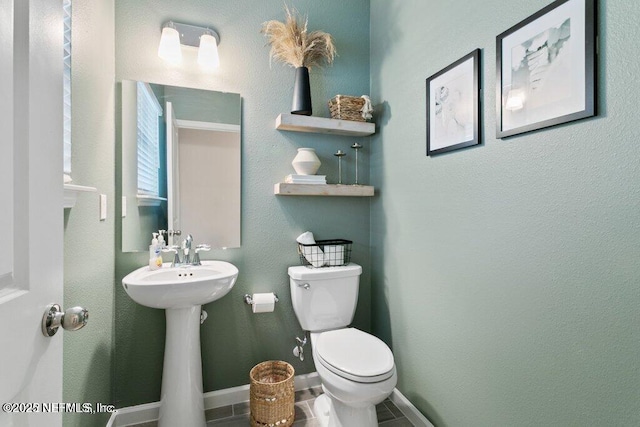 bathroom featuring toilet and tile patterned flooring