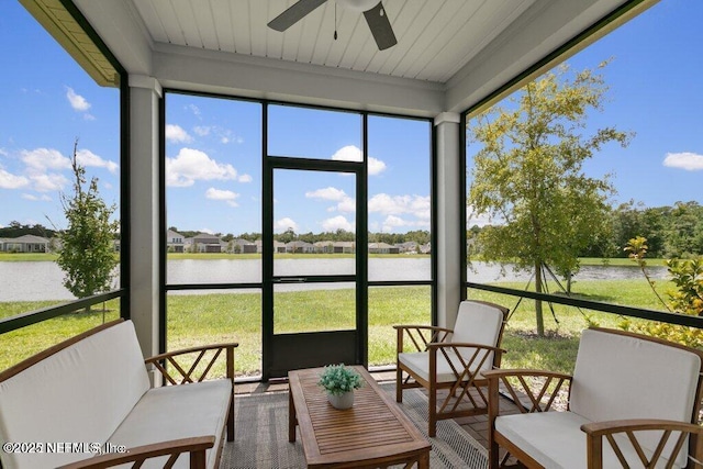 sunroom with ceiling fan, a water view, and a healthy amount of sunlight