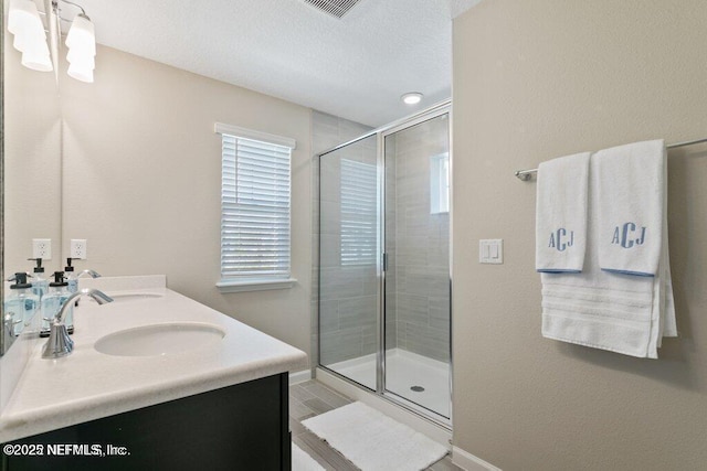 bathroom with a shower with door and vanity