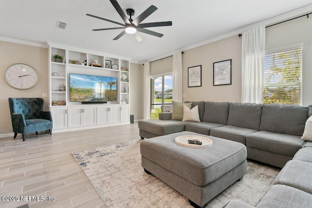 living room featuring crown molding, light hardwood / wood-style floors, and ceiling fan