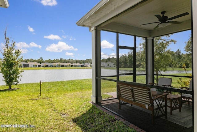 sunroom with a water view and ceiling fan