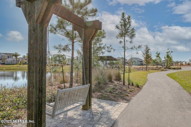 view of home's community featuring a water view and a yard