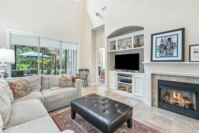 living room featuring a fireplace, light tile patterned floors, and high vaulted ceiling