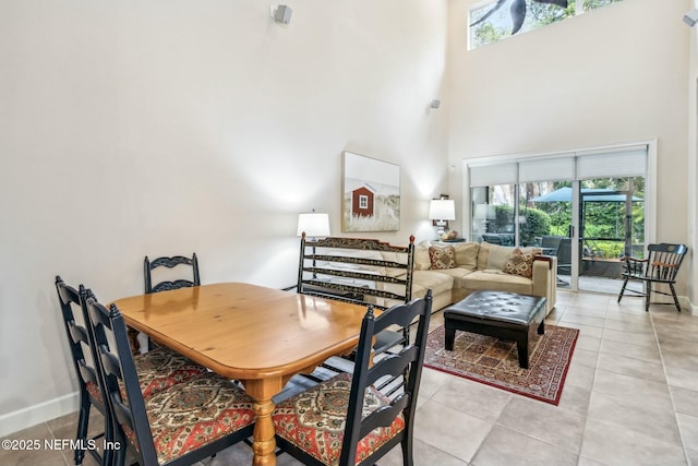 tiled dining space with a high ceiling