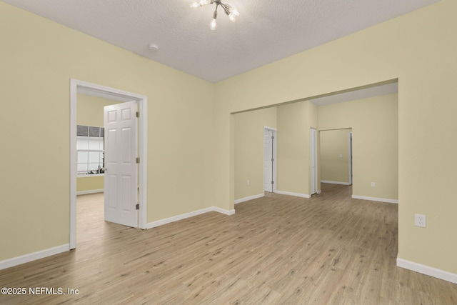 spare room with light hardwood / wood-style flooring and a textured ceiling