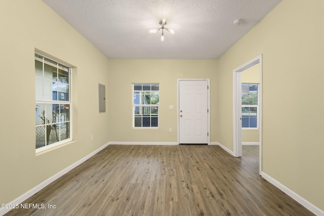 foyer featuring hardwood / wood-style floors, electric panel, and a textured ceiling