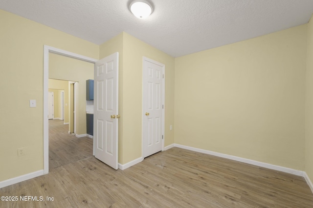 unfurnished bedroom featuring hardwood / wood-style flooring, a closet, and a textured ceiling