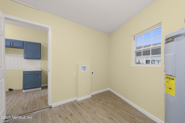 laundry area with water heater, electric dryer hookup, washer hookup, light hardwood / wood-style floors, and a textured ceiling