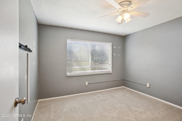 carpeted spare room featuring a textured ceiling and ceiling fan