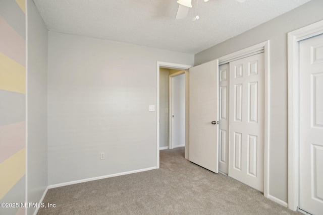 unfurnished bedroom with light carpet, a textured ceiling, a closet, and ceiling fan