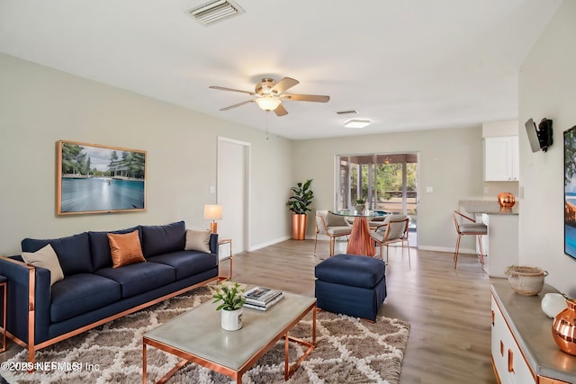 living room with light hardwood / wood-style floors and ceiling fan