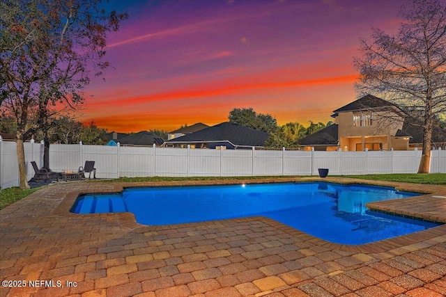 pool at dusk featuring a patio area