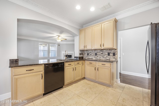 kitchen featuring crown molding, stainless steel refrigerator, dishwasher, ceiling fan, and dark stone counters