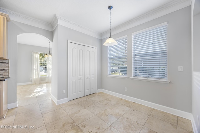 interior space with light tile patterned floors and crown molding