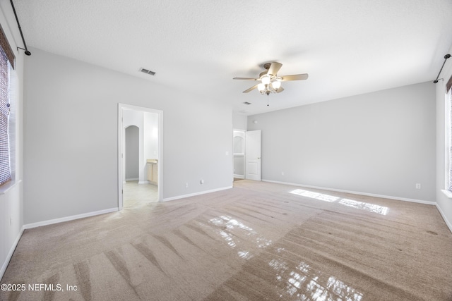 carpeted spare room featuring a textured ceiling and ceiling fan