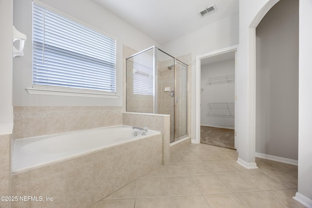 bathroom with tile patterned flooring and separate shower and tub