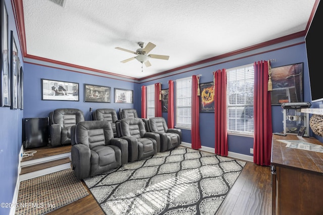 cinema featuring hardwood / wood-style flooring, ornamental molding, ceiling fan, and a textured ceiling