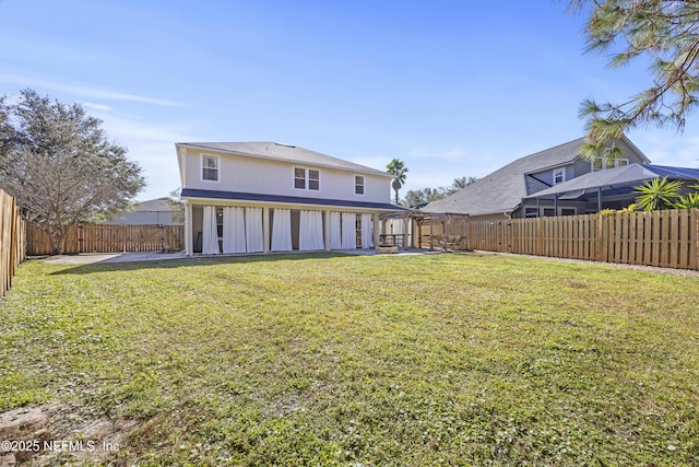 back of property with a patio area and a lawn