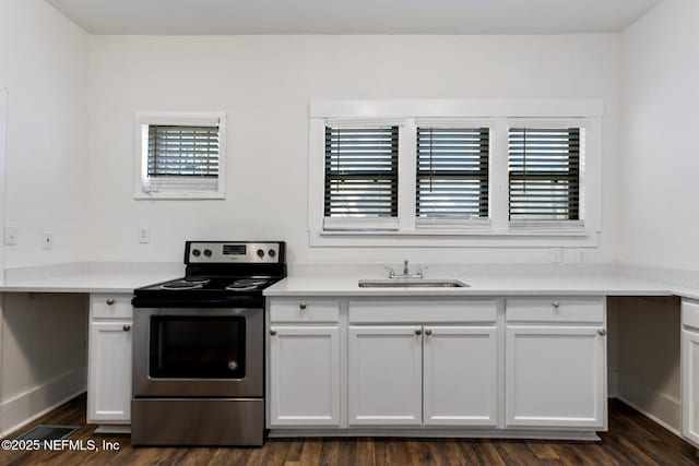 kitchen featuring dark wood-type flooring, sink, stainless steel electric range, and white cabinets