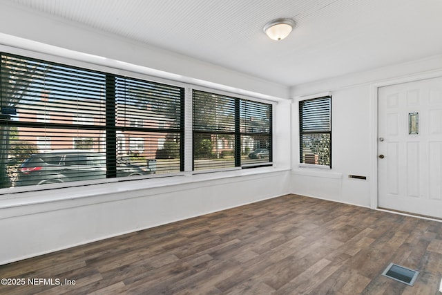 foyer with ornamental molding and hardwood / wood-style floors