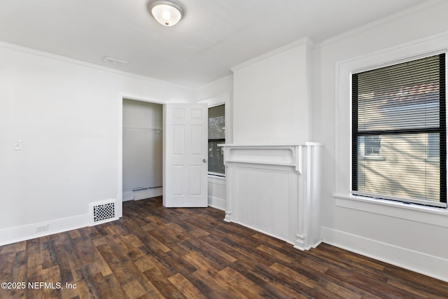 unfurnished bedroom featuring dark wood-type flooring, ornamental molding, and a closet