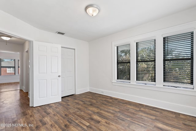 unfurnished bedroom with dark hardwood / wood-style floors and a closet