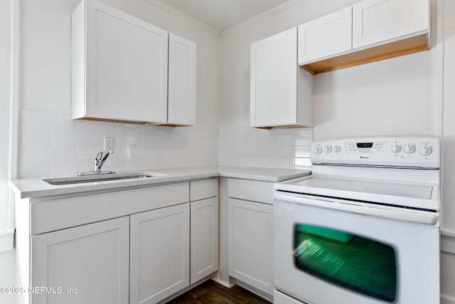 kitchen with white electric range oven, sink, decorative backsplash, and white cabinets