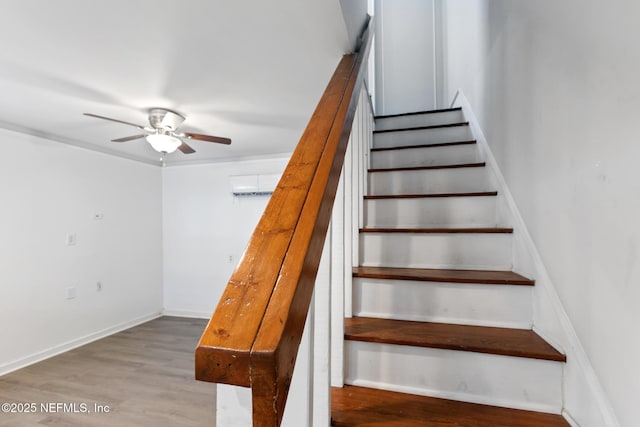 staircase with hardwood / wood-style floors and ceiling fan