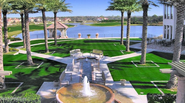 surrounding community featuring a gazebo, a lawn, and a water view