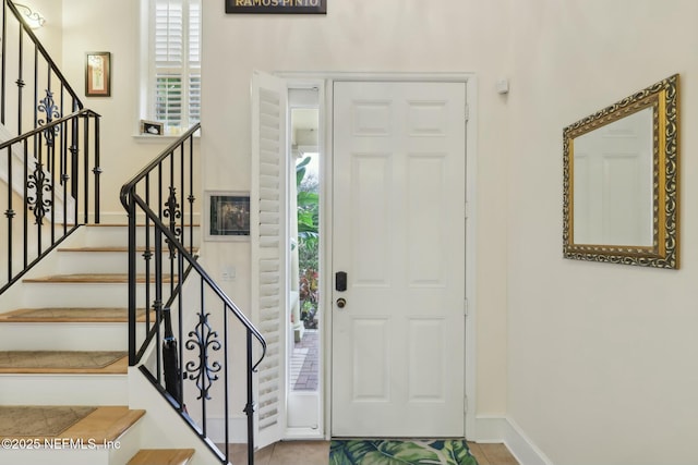 entrance foyer with stairway and baseboards