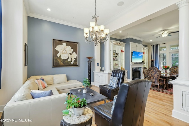 living area featuring a fireplace, decorative columns, light wood finished floors, recessed lighting, and ornamental molding