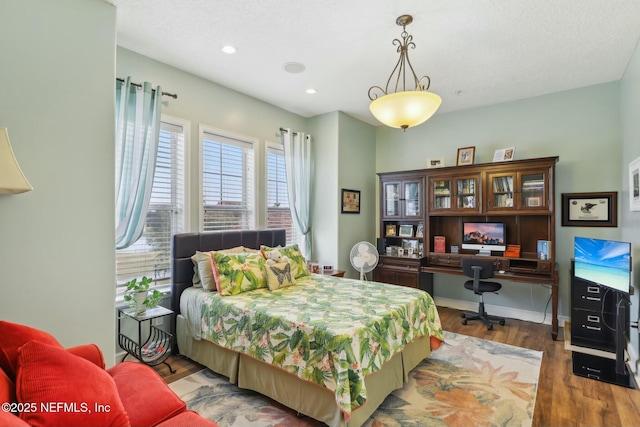 bedroom with baseboards, wood finished floors, and recessed lighting