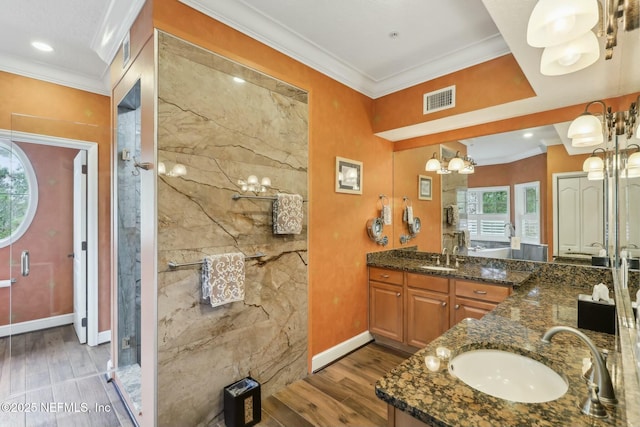 full bathroom featuring ornamental molding, visible vents, a sink, and wood finished floors