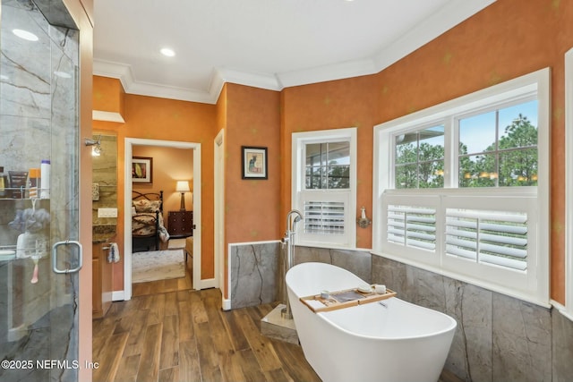 full bathroom featuring wood finished floors, a soaking tub, a stall shower, ensuite bath, and crown molding