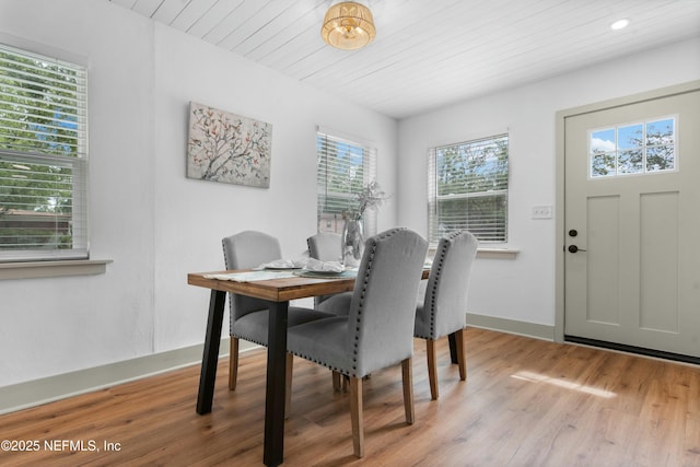 dining room with wood ceiling and light wood-type flooring