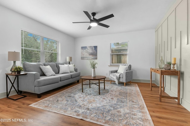 living room with wood-type flooring and ceiling fan