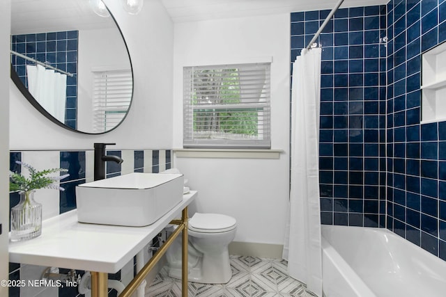 full bathroom with sink, toilet, and shower / tub combo with curtain