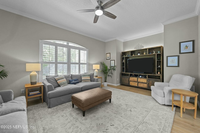 living room with crown molding, ceiling fan, wood-type flooring, and a textured ceiling