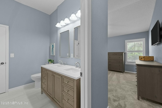 bathroom featuring vanity, toilet, and a textured ceiling