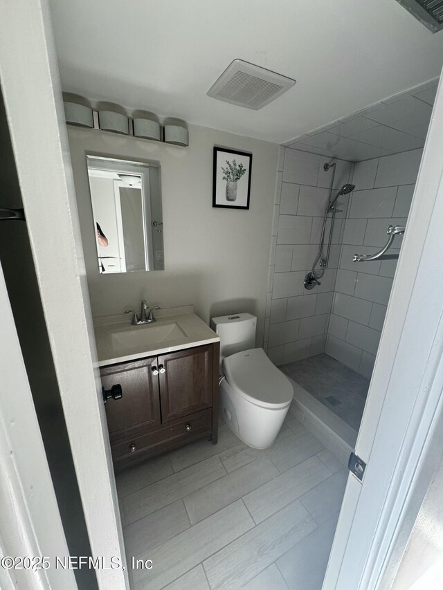 5500 Ocean Shore Blvd Unit 61, Ormond Beach, FL 32176 - bathroom with toilet, visible vents, tiled shower, and vanity