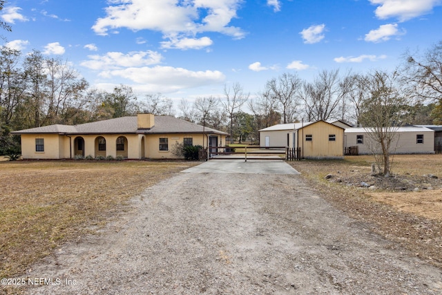 view of front of home with a garage and an outbuilding