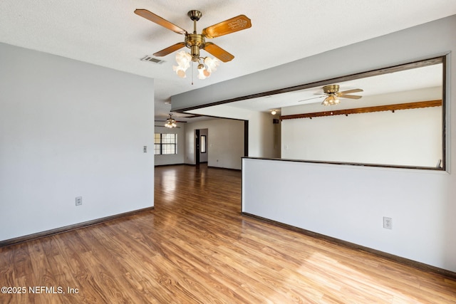 unfurnished room featuring ceiling fan, hardwood / wood-style flooring, and a textured ceiling