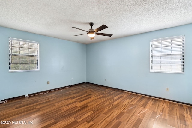 spare room with ceiling fan, dark wood-type flooring, and a textured ceiling