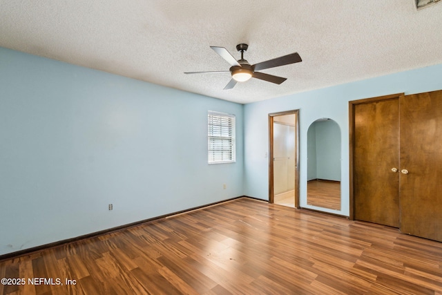 unfurnished bedroom with hardwood / wood-style flooring, ceiling fan, and a textured ceiling