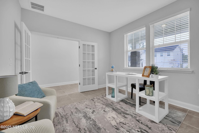 tiled home office with french doors and a healthy amount of sunlight