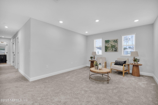 living area featuring light carpet