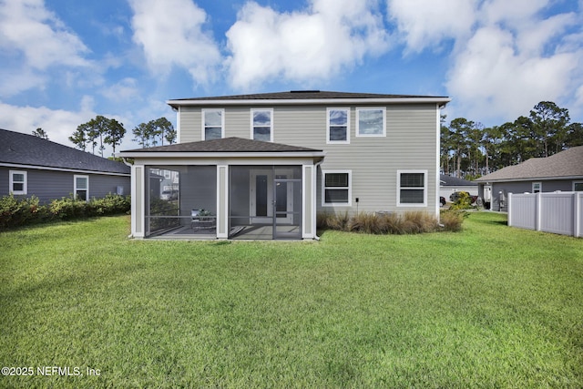 back of property with a sunroom and a lawn