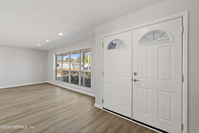 foyer with light hardwood / wood-style floors and a textured ceiling