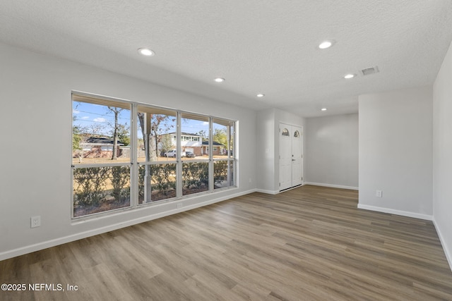 empty room featuring hardwood / wood-style floors and a textured ceiling