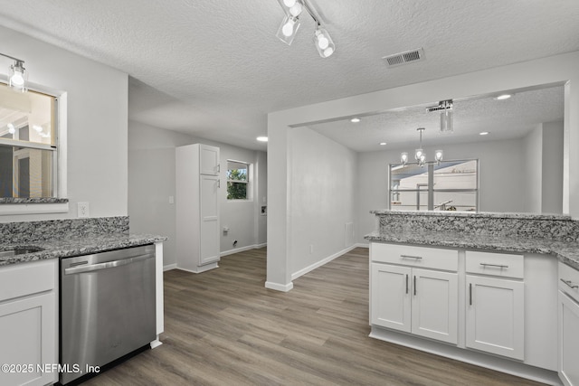 kitchen with white cabinetry, hanging light fixtures, stainless steel dishwasher, light stone countertops, and a textured ceiling